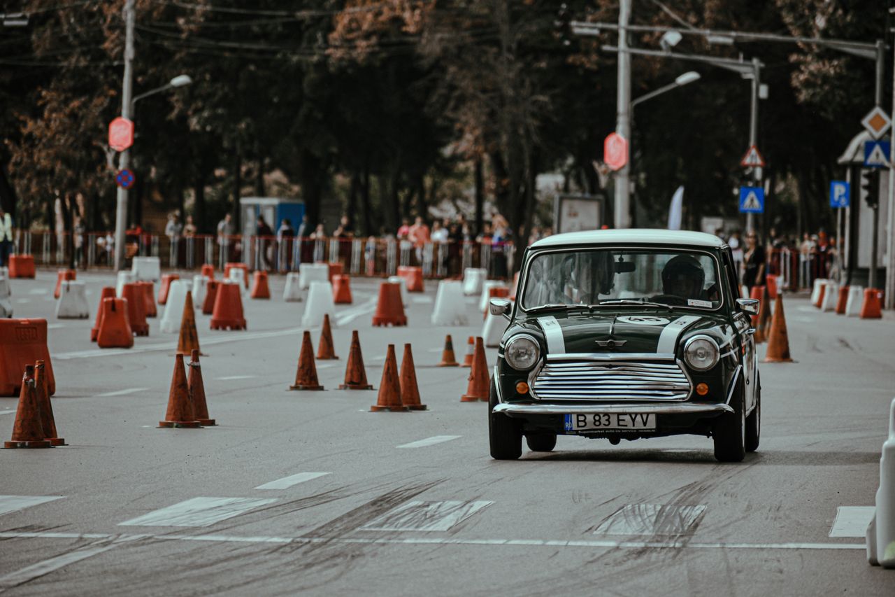 Black old timer car driving on racetrack of city street while taking part in rally