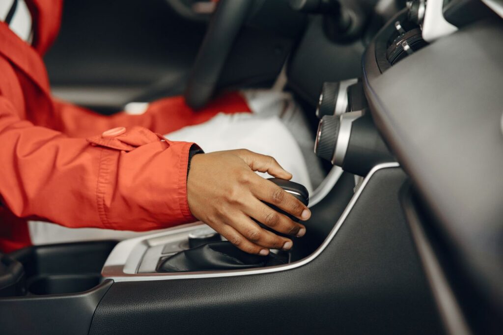 The Art of Drawing Readers In: Your attractive post title goes here Close-up view of a person shifting gears in a car interior, illustrating driving expertise.