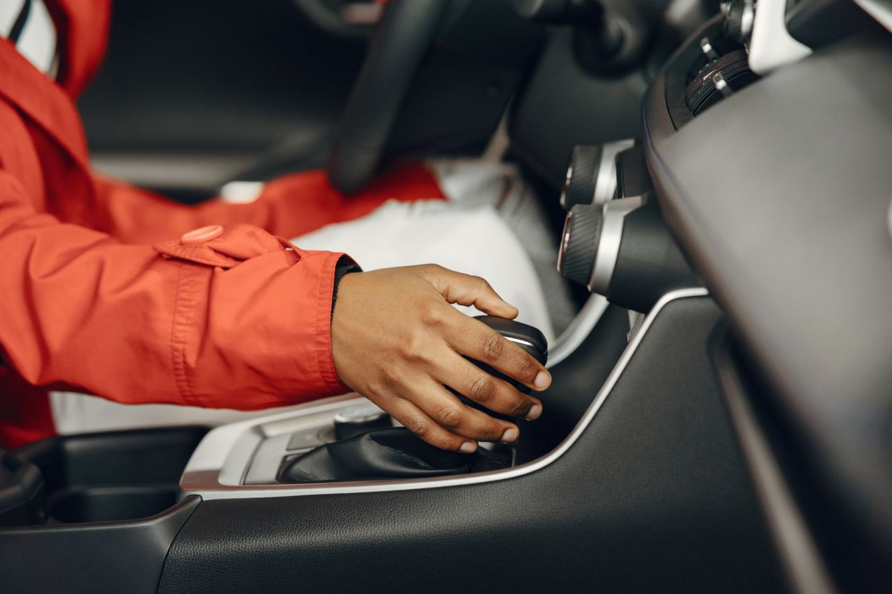 The Art of Drawing Readers In: Your attractive post title goes here Close-up view of a person shifting gears in a car interior, illustrating driving expertise.